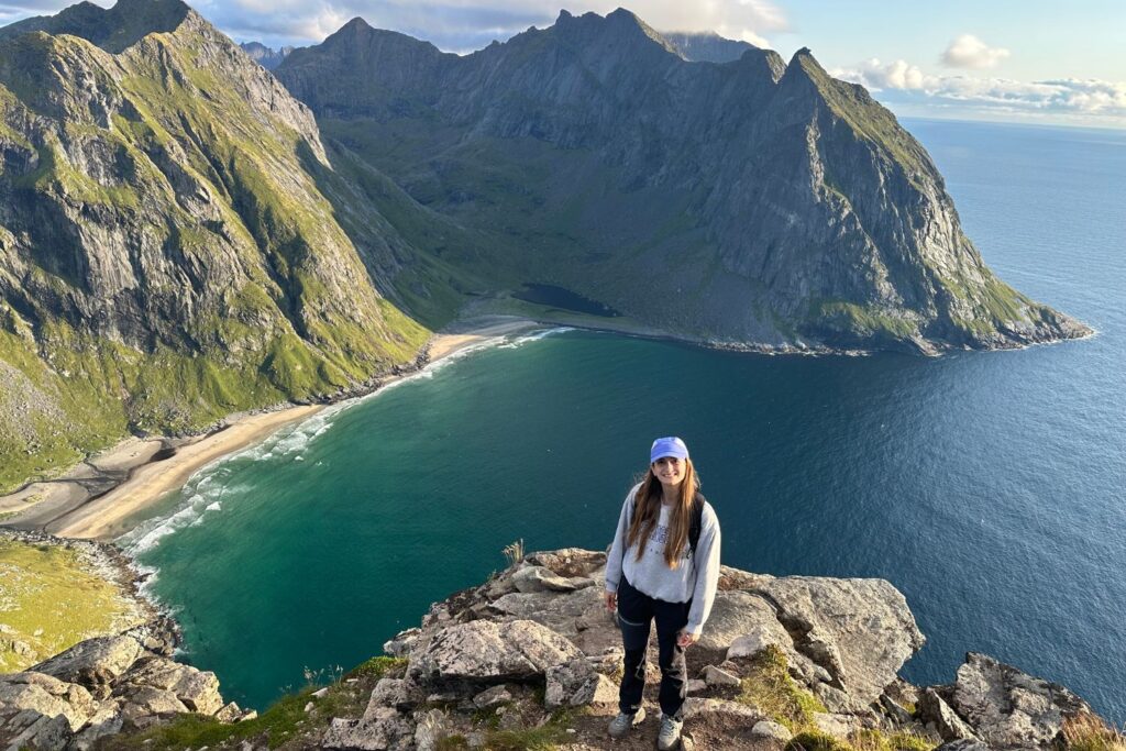 Enfermera de Ecura Care frente a una playa rodeada de montañas en Noruega