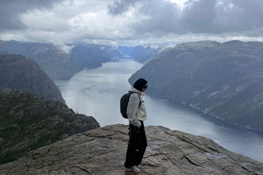 Enfermera de Ecura Care contemplando un fiordo desde una montaña en Noruega